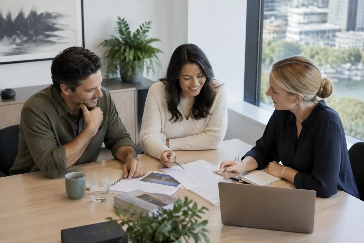 Three professionals collaborating around a meeting table